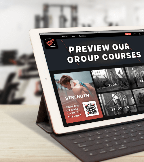 A tablet at a gym that promotes group courses with a QR Code that urges users to view a video playlist of the courses on their smartphones.