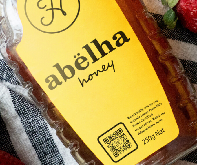 A label of a bottled honey with a QR Code that links to a video playlist showcasing locally-sourced ingredients.
