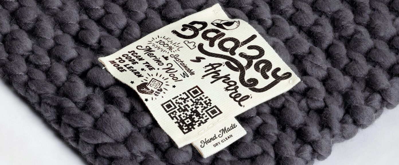 A clothing label on a sweater with a QR Code that contains sustainability information in a PDF file.