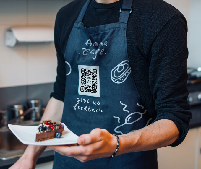 A chef’s apron at a cafe with a QR Code that lets customers leave detailed feedback when scanned.