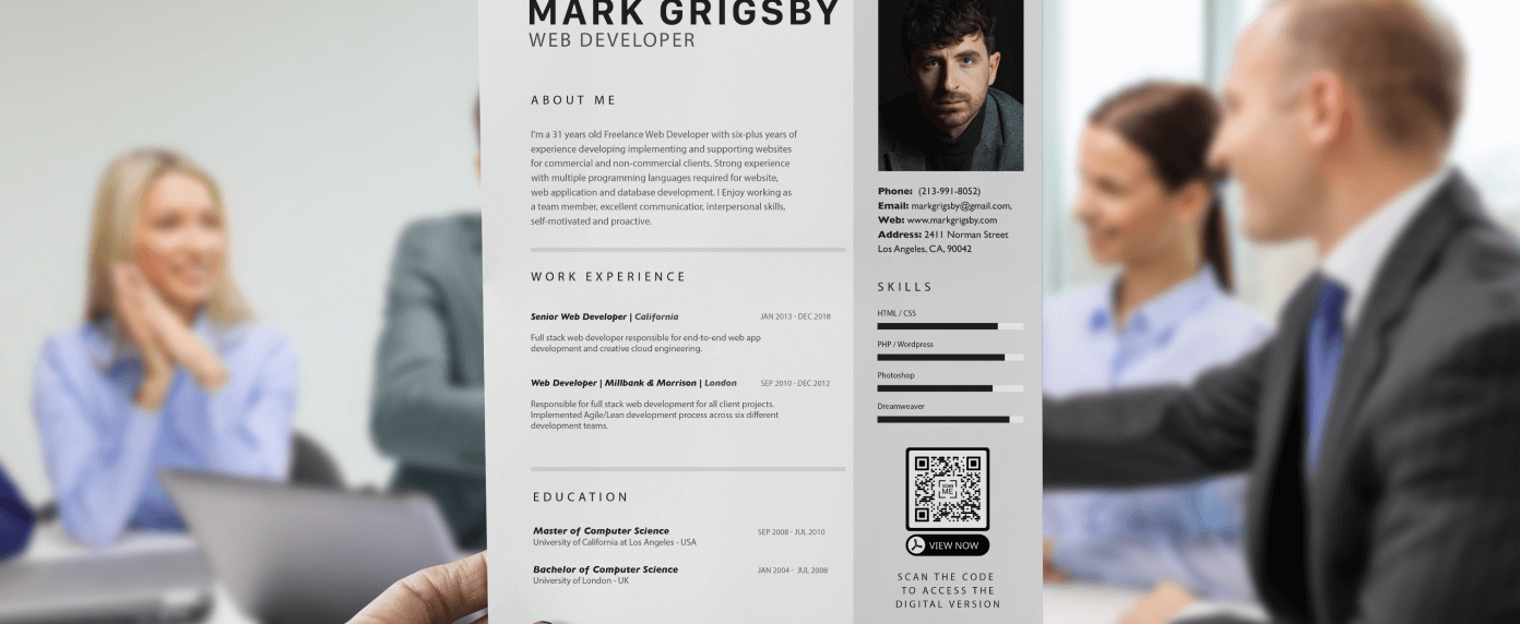 A hand holding up a resume for a web developer that has a QR Code in the bottom right prompting the reader to scan to access the digital version of their resume.