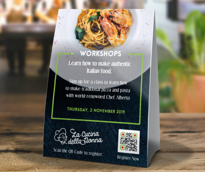 Table tent at a restaurant with a QR Code that links to an event registration page.