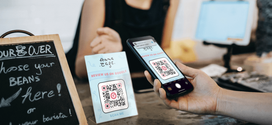 A hand pointing a smartphone at a Google review QR Code at a place of business.